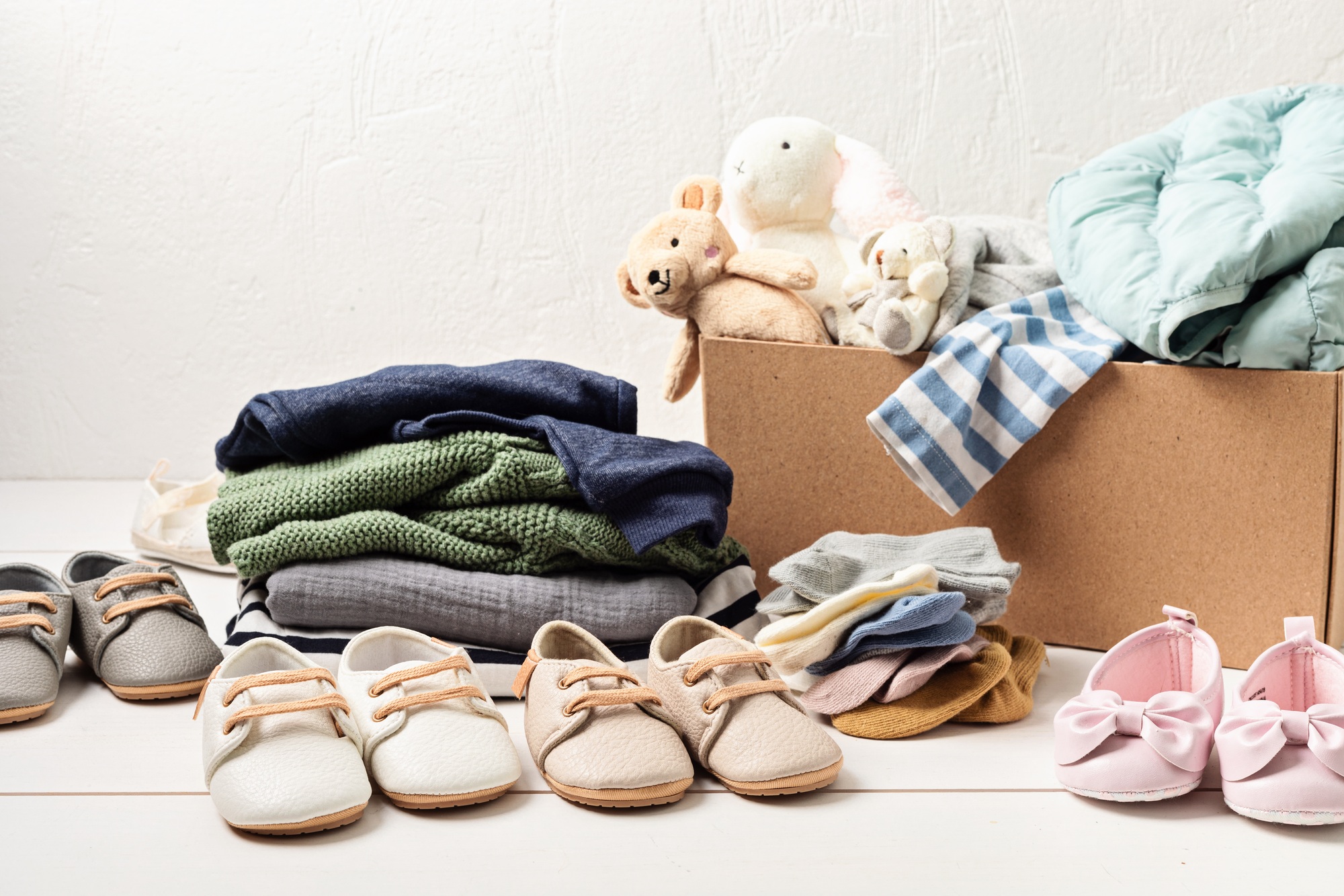 Baby and child clothes, toys in box. Second hand apparel idea